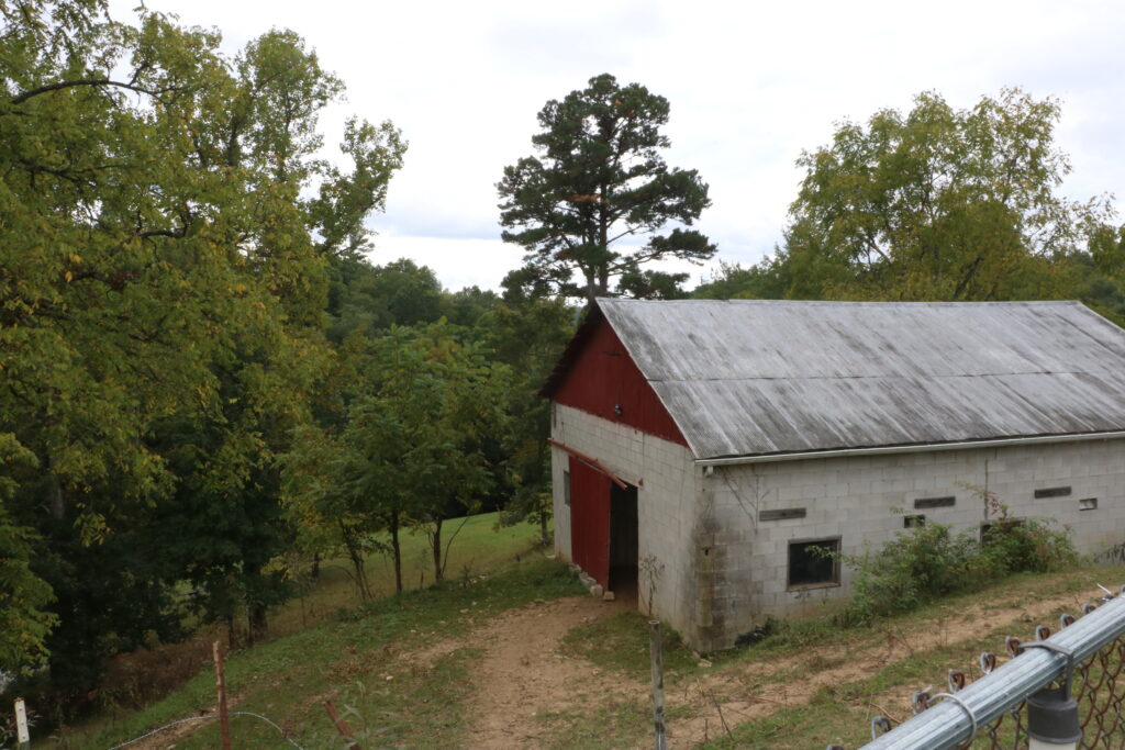 A red and white barn sits on the wooded hill near the Wolfe-Lee county line.