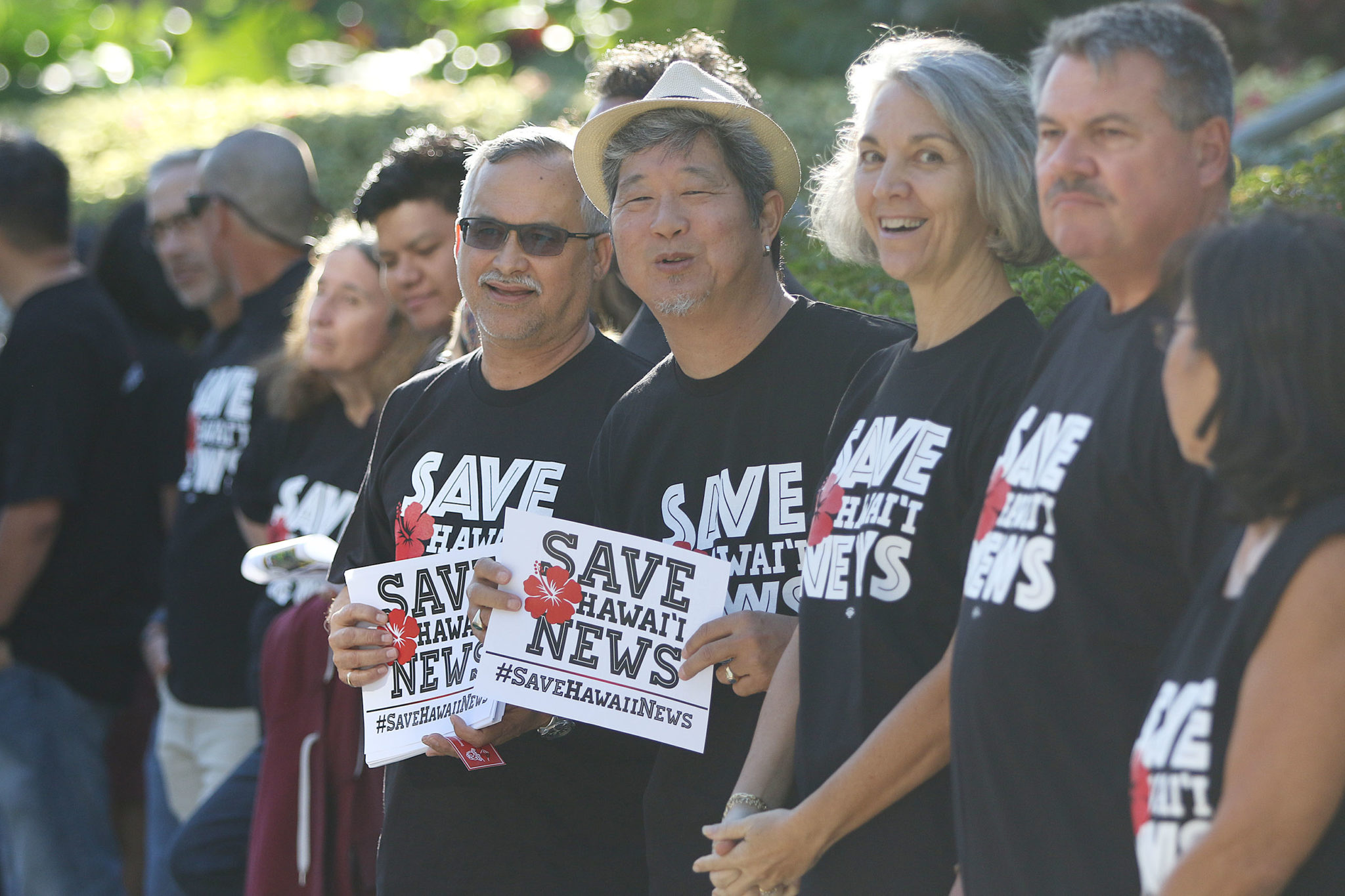 Star Advertiser employees Rob Perez, left, and right, Bryant Fukutomi hold Save Hawaii News signs outside the Honolulu Star Advertiser offices.