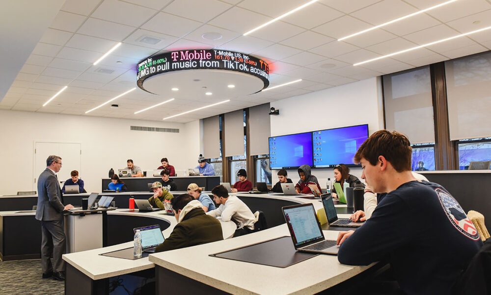 Students take a class in the newly renovated Finance Lab with a stock ticker on the ceiling