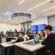 Students take a class in the newly renovated Finance Lab with a stock ticker on the ceiling