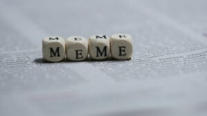 Four dice on a newspaper with letters instead of dots, spelling out the word 