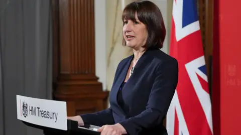 Getty Images Chancellor Rachel Reeves standing at a lectern with a plaque from Her Majesty's Treasury in front